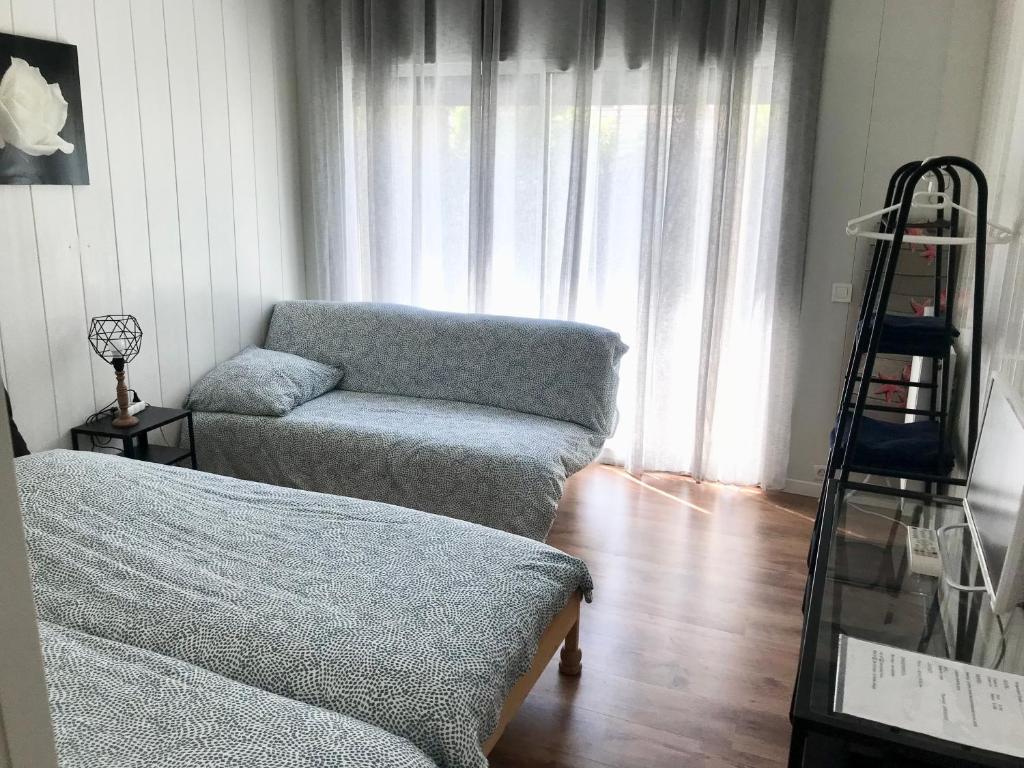 uma sala de estar com um sofá e uma cadeira em Studio indépendant dans une maison avec jardin em Serris