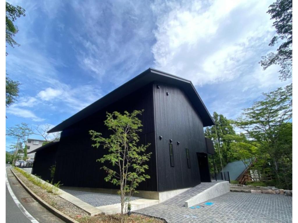 Un edificio negro con un pequeño árbol delante. en MONS GORA - Vacation STAY 68078v, en Onsensō
