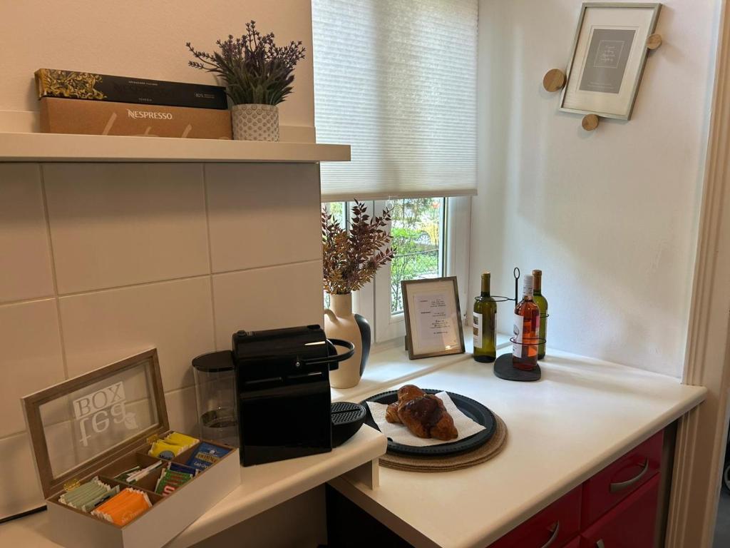 a kitchen counter with a plate of food and bottles of wine at Apartment 5 min Schönbrunn Gloriette, Direct to City Center, Free Parking in Vienna