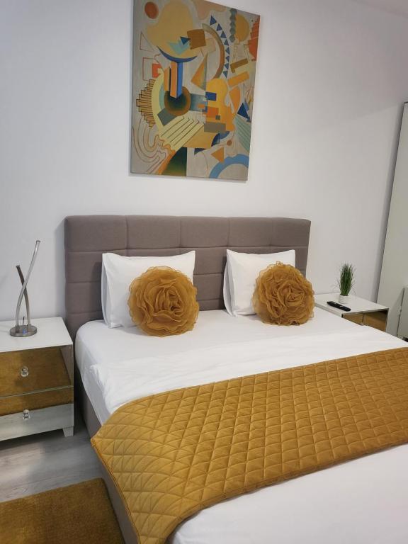 a bedroom with a bed with orange pillows on it at Hils Pallady Apartment Lyly in Bucharest