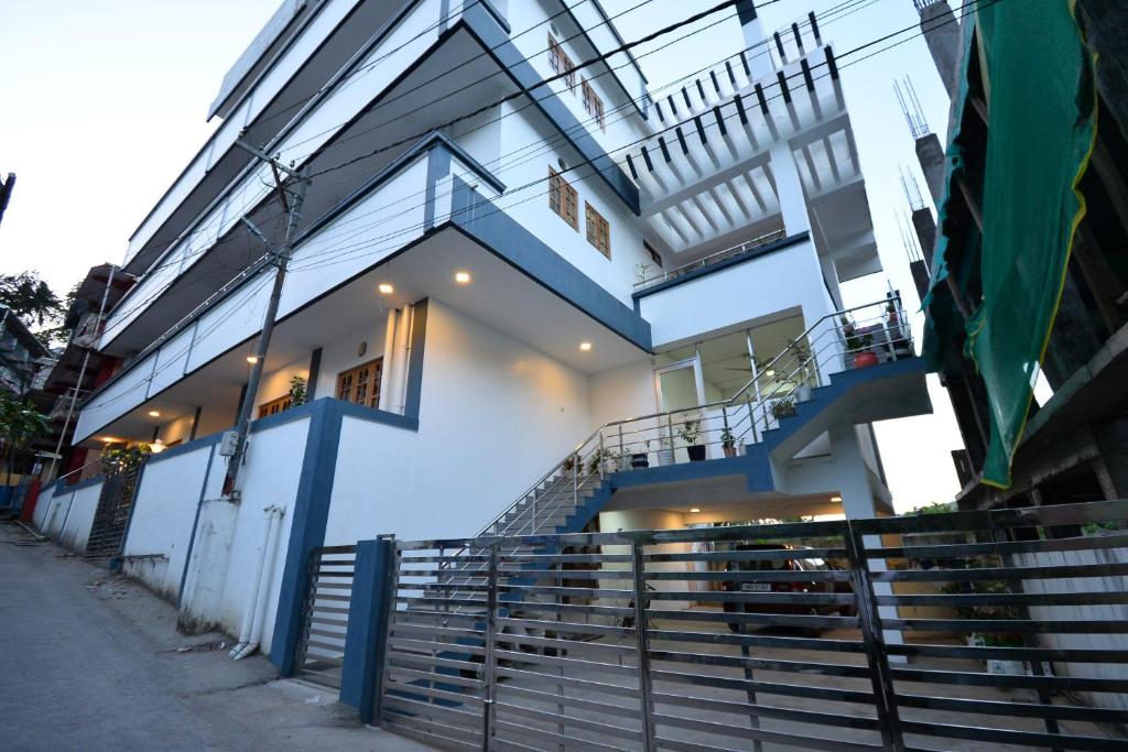 a white house with a staircase in front of it at The Hook BnB, Port Blair in Haddo