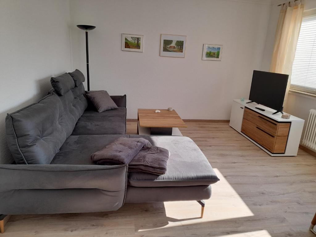 salon z kanapą i telewizorem w obiekcie Ferienwohnung in Lemgo-Brake, 3 Zimmer w mieście Lemgo
