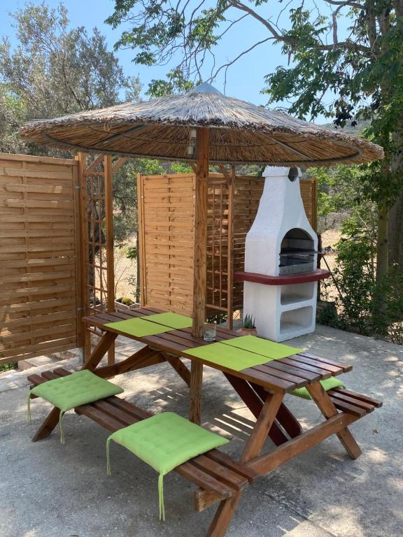 una mesa de picnic con sombrilla y 2 sillas en Euphoria Estate 2, en Agia Marina Aegina