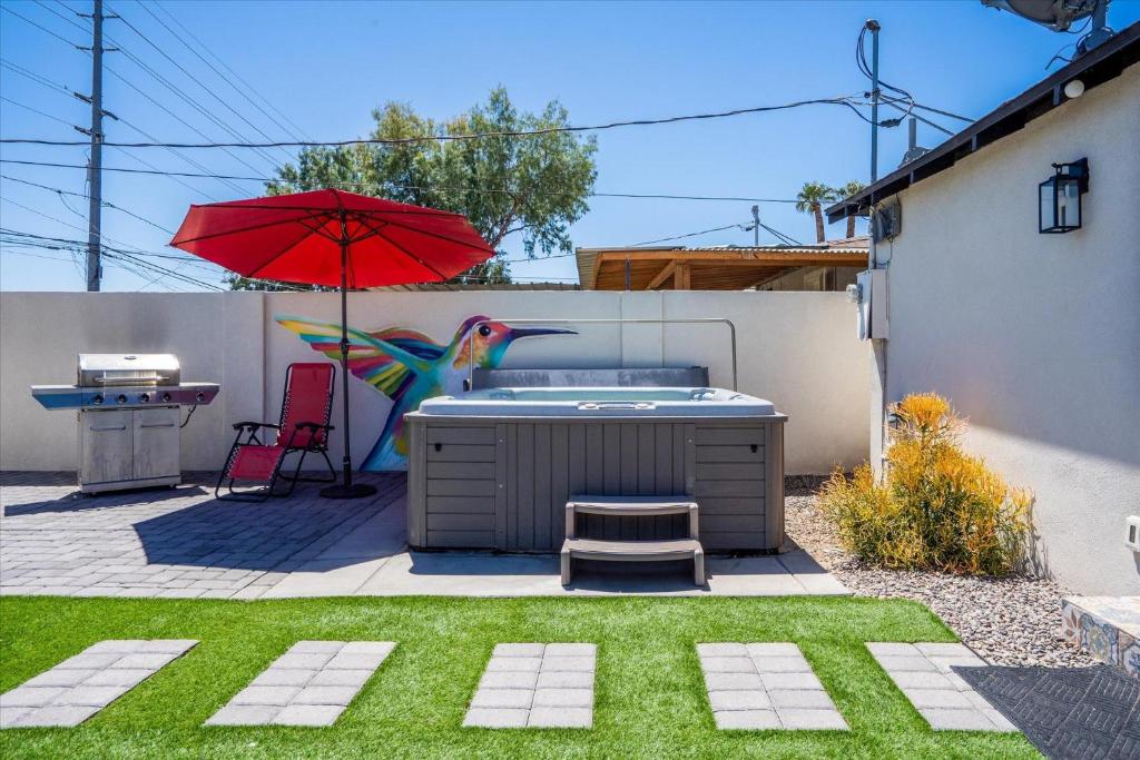 a backyard with a hot tub and an umbrella at The Urban Cowboy Bunk House in Phoenix