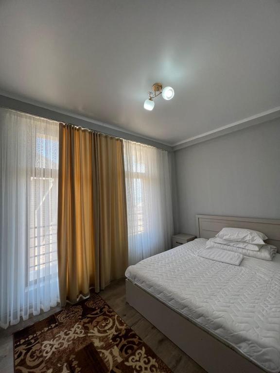 1 dormitorio con cama blanca y ventana en Гостевой дом Razamlux en Bosteri