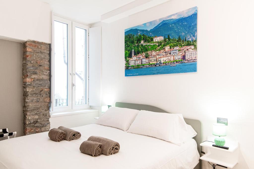 a white bedroom with a white bed with towels on it at Olimpia Via Vitani - The House Of Travelers in Como