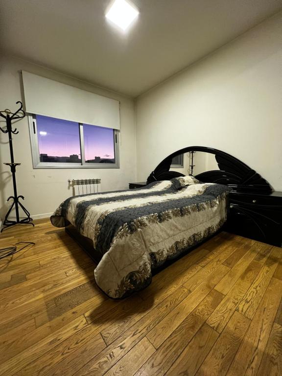 1 dormitorio con 1 cama y suelo de madera en Centro Shopping en Salta