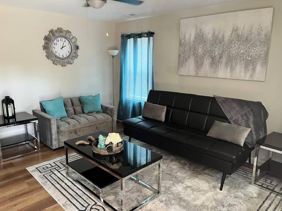a living room with a black couch and a table at New Cozy home: Near Stadium in Columbia