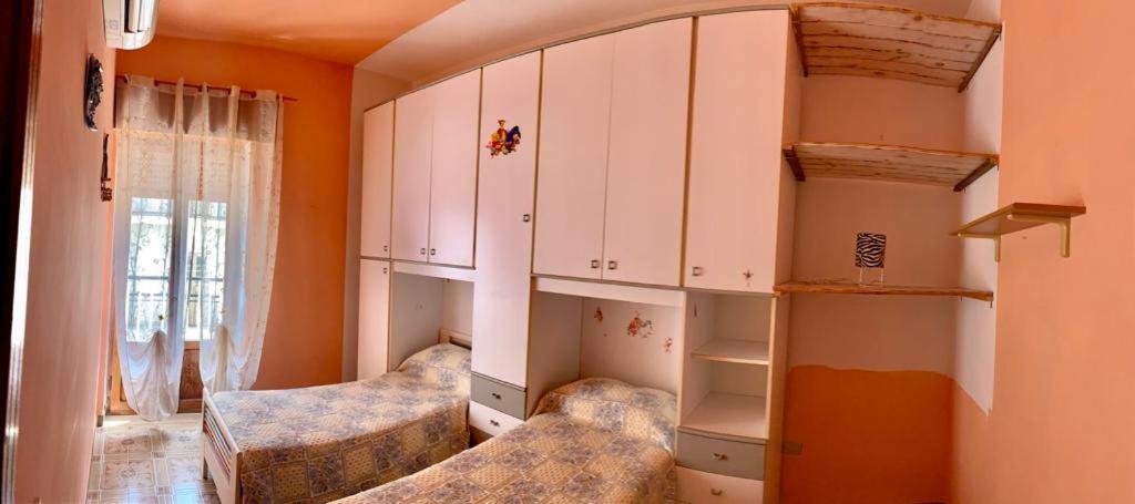 Habitación con 2 camas y espejo. en Casa graziella, en Peschici