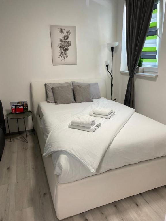 białe łóżko z dwoma ręcznikami na górze w obiekcie Aspen Studio Apartment + FREE Parking w Lublanie