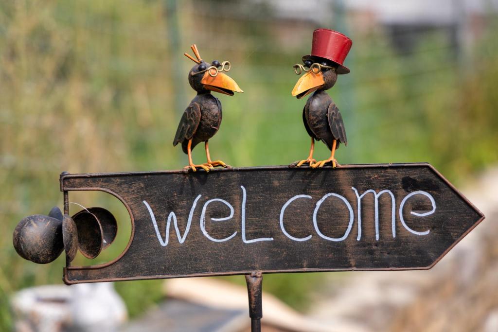 two birds on top of a welcome sign at Au Repos de la Redoute in Aywaille
