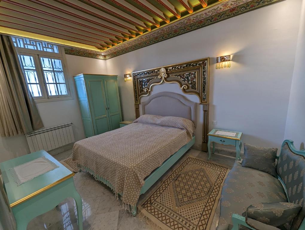 a bedroom with a bed and a couch at Dar Hamouda Guest House - Médina de Tunis in Tunis