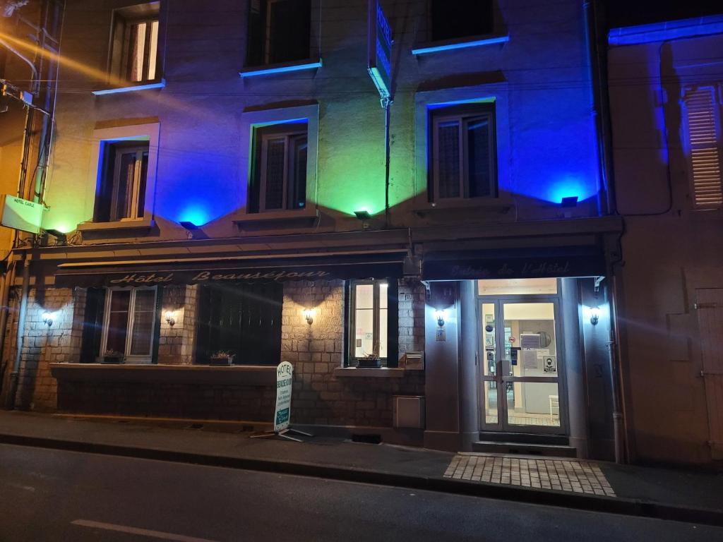 a building with blue and green lights on a street at Hôtel Beauséjour in Nevers