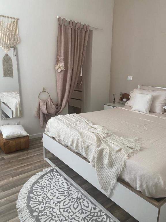 a bedroom with a white bed and a mirror at MAISON REBECCA in Carpi