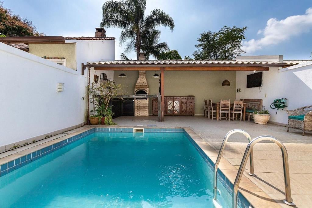 uma piscina no quintal de uma casa em Casa incrível com 04 suítes - 5 min de Itacoatiara em Niterói