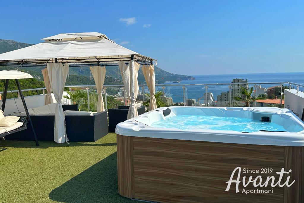 a hot tub with an umbrella on top of a roof at Apartmani Avanti Becici in Becici
