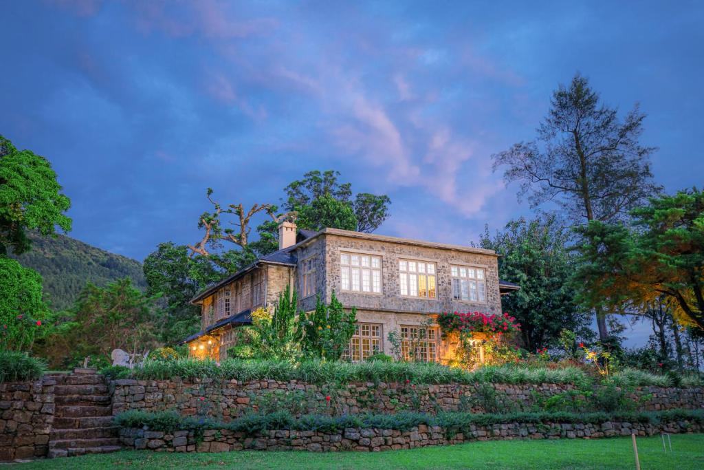 a large stone house with a stone wall at Taylor's Hill in Bopitiya