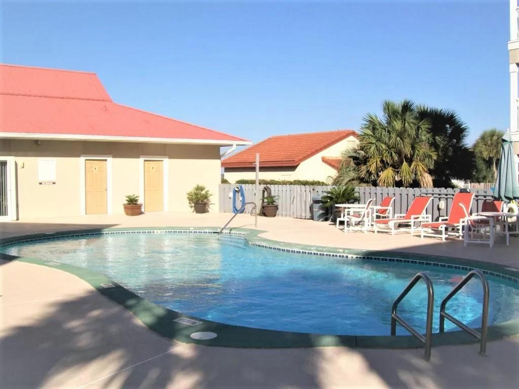 a swimming pool at a resort with chairs and a building at Sunset Heaven in Navarre