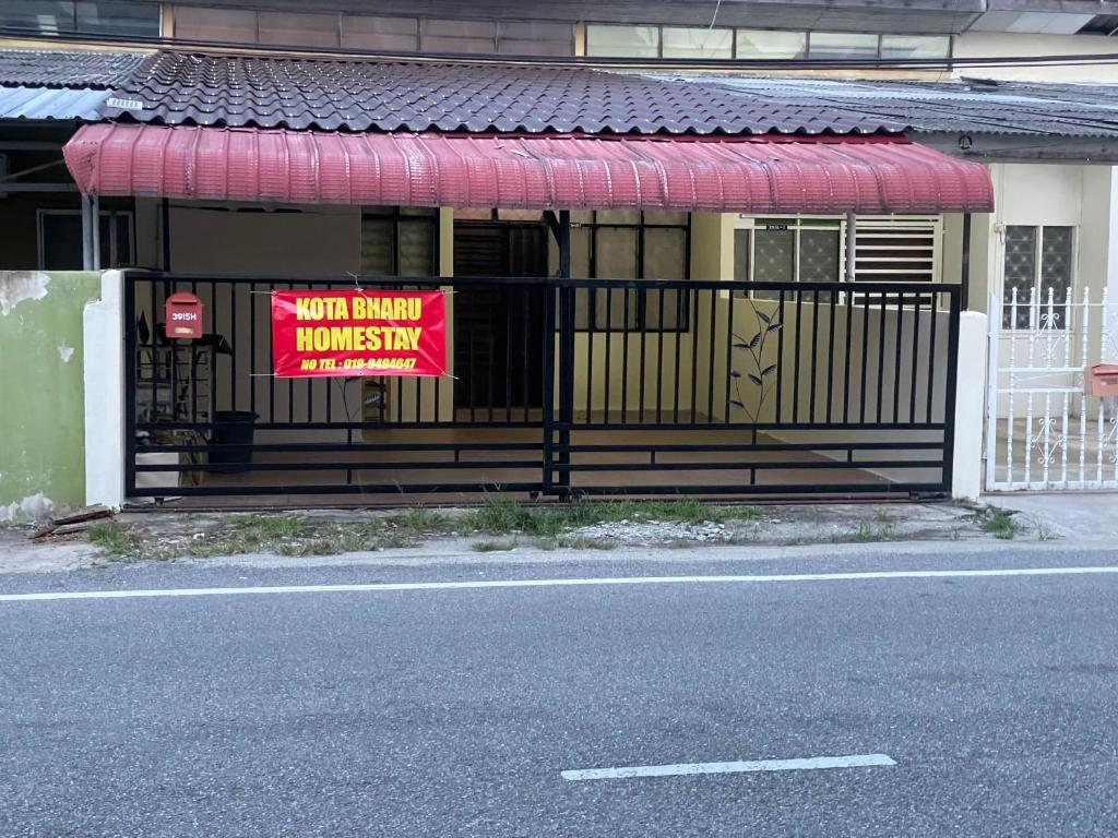 un cartel en una puerta delante de una casa en Kota Bharu Homestay, en Kota Bharu