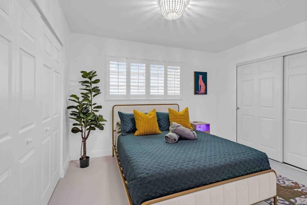 - une chambre avec un lit doté d'oreillers jaunes et bleus dans l'établissement Miami Luxurious Retreat! Next to Miami beach & Airport, à Miami