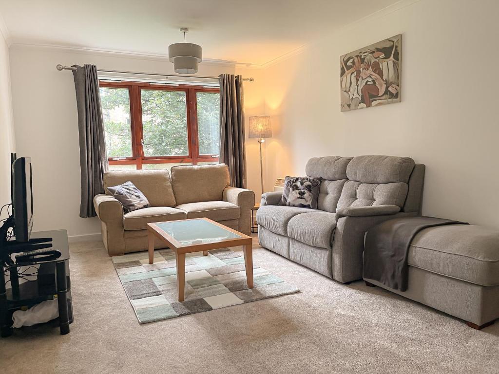 uma sala de estar com um sofá e uma mesa em Spacious, central and newly decorated apartment em Edinburgo