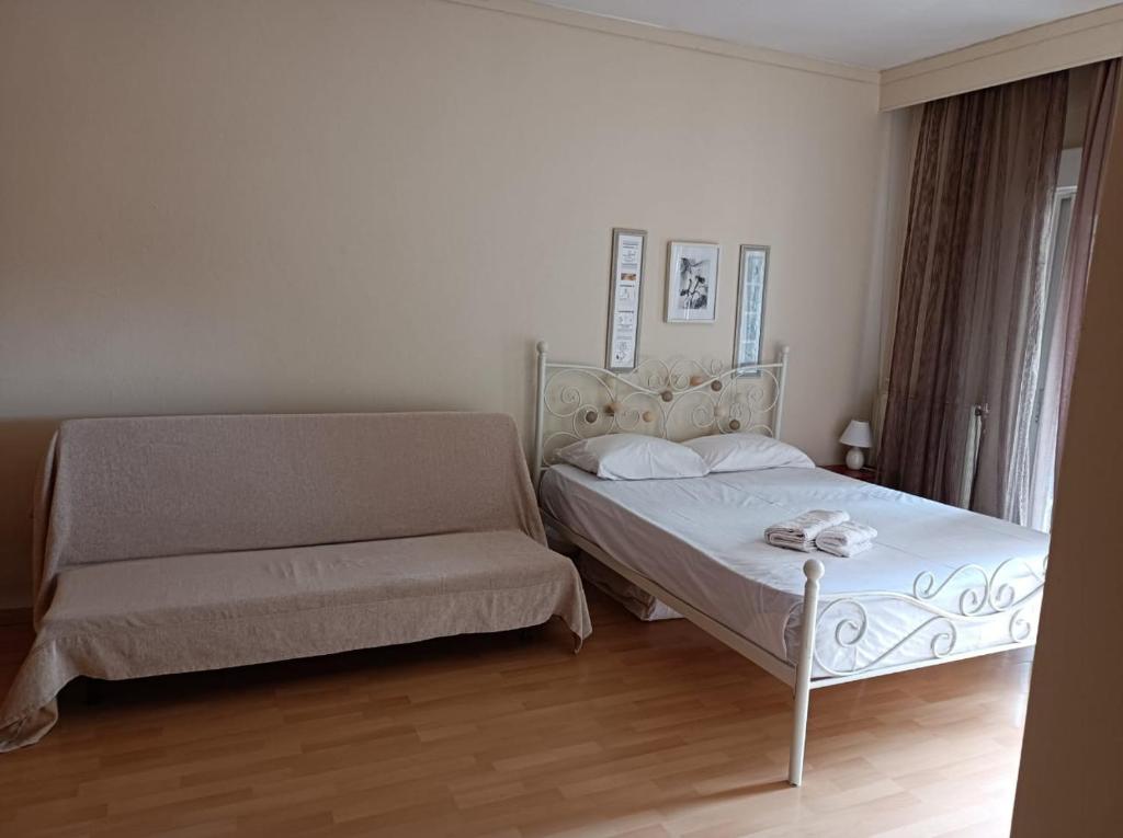 una camera con letto e divano di LOVELY APARTMENT a PalaiónTsiflíkion