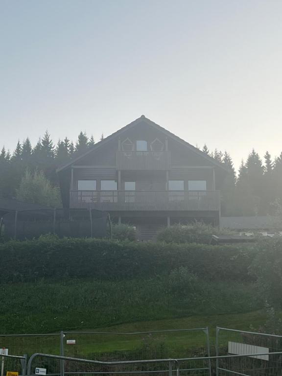 uma casa grande num campo nevoeiro com em Buvika Panorama 