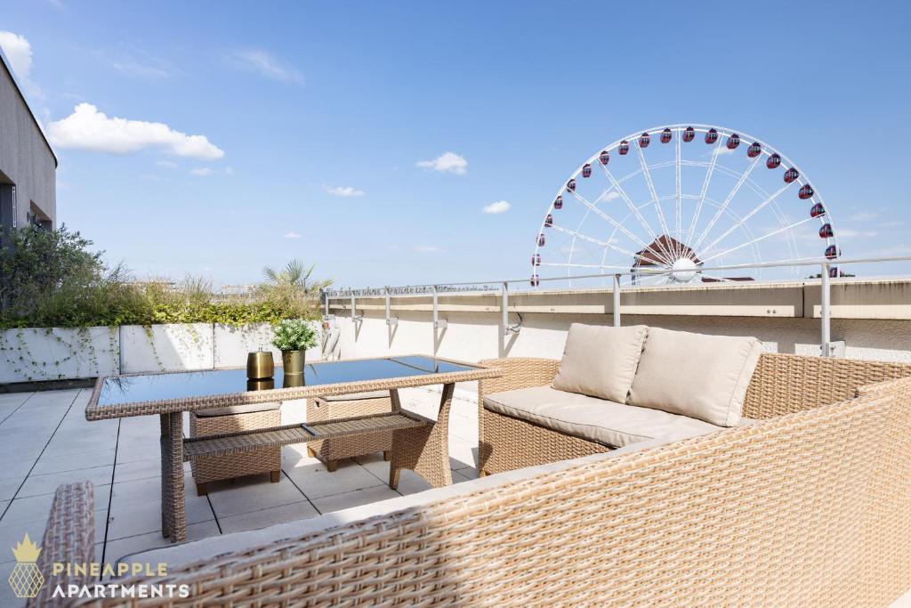 une terrasse avec une table et une roue ferris dans l'établissement Pineapple Apartments Penthouse am Zwinger - 162 qm - 1x free parking, à Dresde