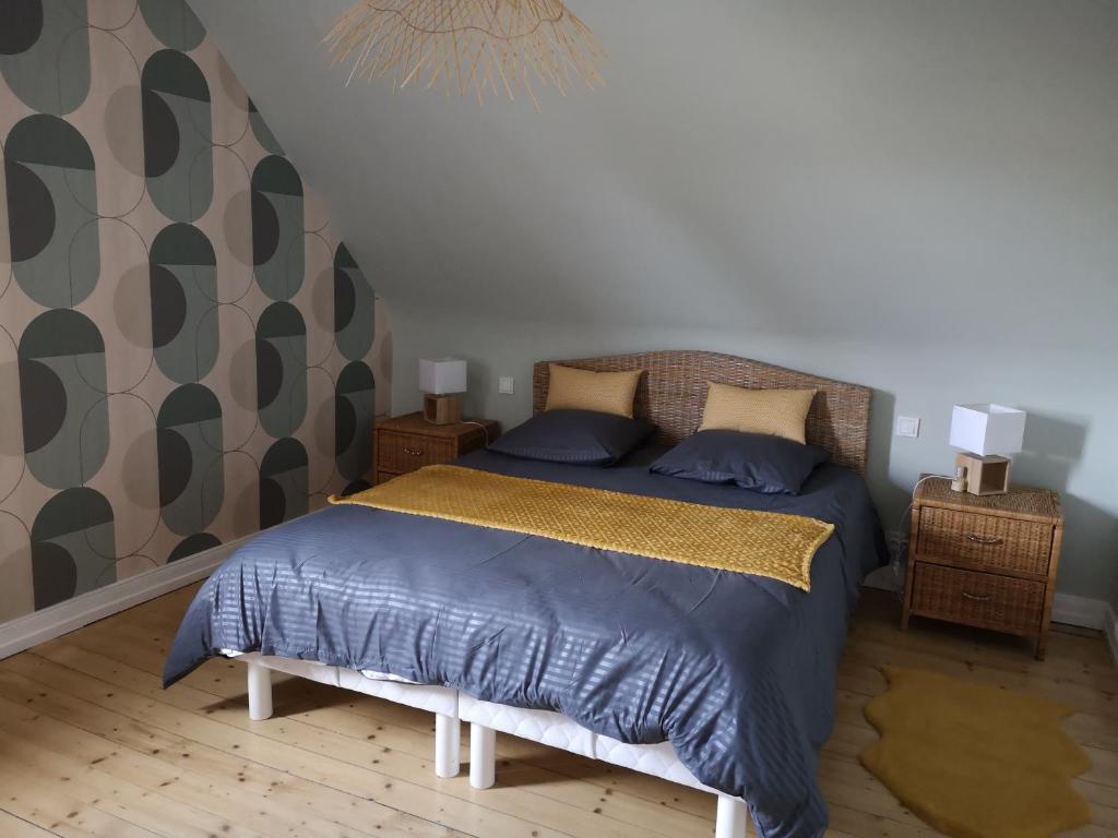 a bedroom with a bed with a blue comforter at Le logis du mineur Chez Agnès et Joël in Staffelfelden