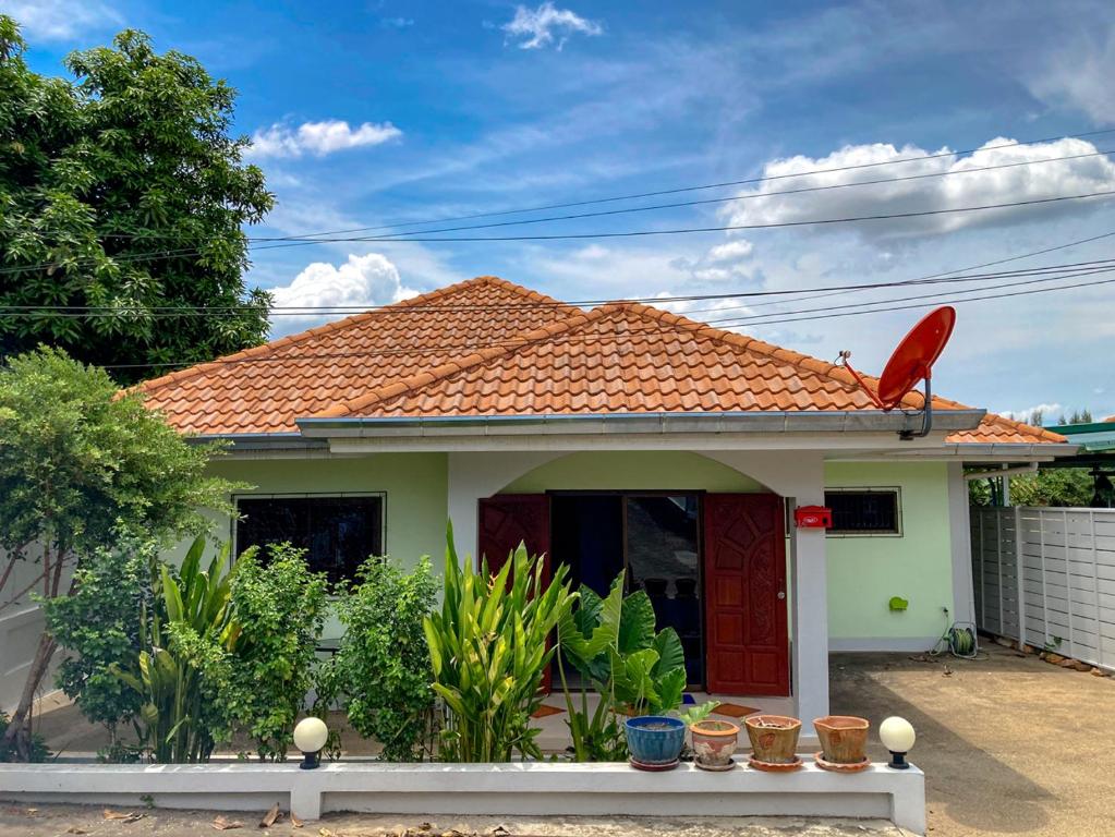 ein kleines Haus mit einem roten Vogel auf dem Dach in der Unterkunft THAIGO Comfort Stay - Private House in Central Kanchanaburi in Kanchanaburi