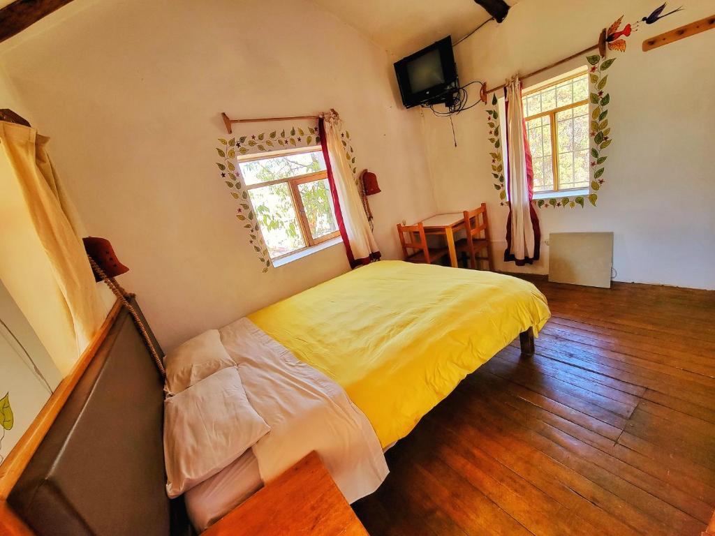 1 dormitorio con cama, mesa y ventana en La Casa de Campo, en Cusco