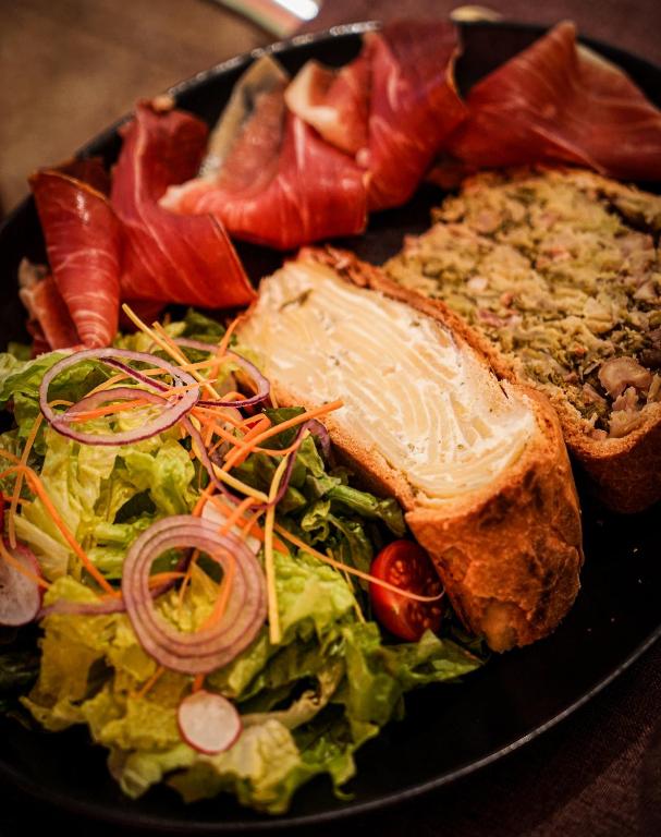 a plate of food with a salad and a sandwich at Hotel Le Faranchin in Villar-dʼArène