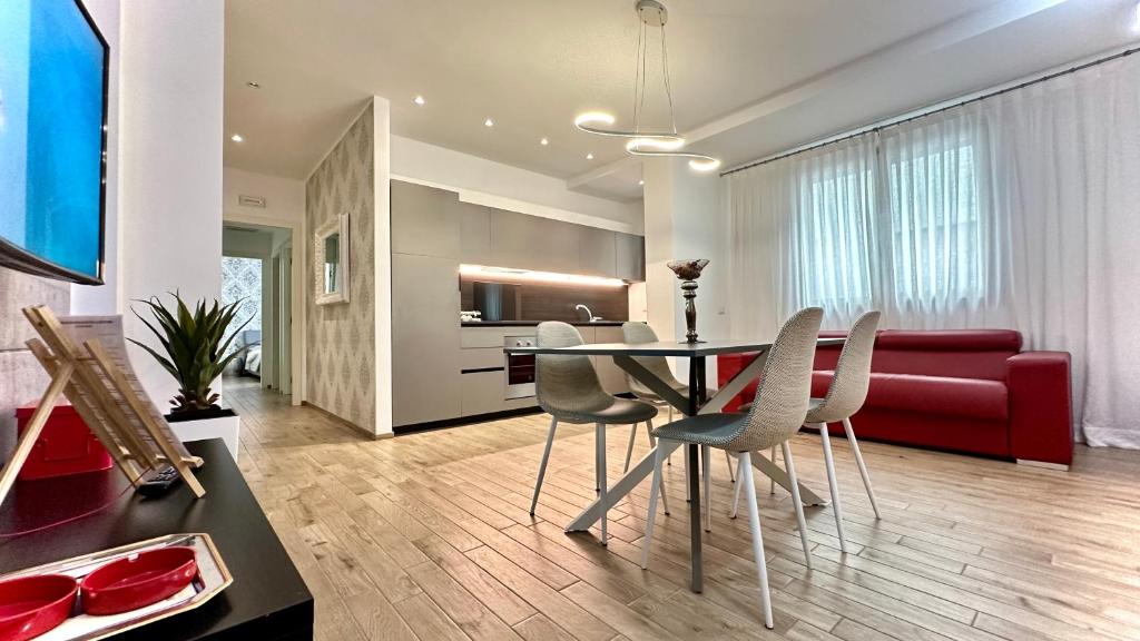- un salon avec une table, des chaises et un canapé rouge dans l'établissement LuxurySmart, à Misano Adriatico