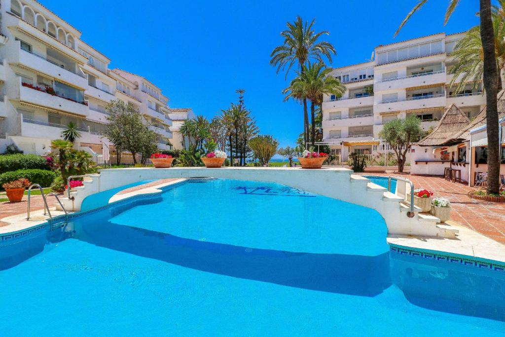 una gran piscina frente a un edificio en Luxury with pool view - Playa Real beachfront, en Marbella