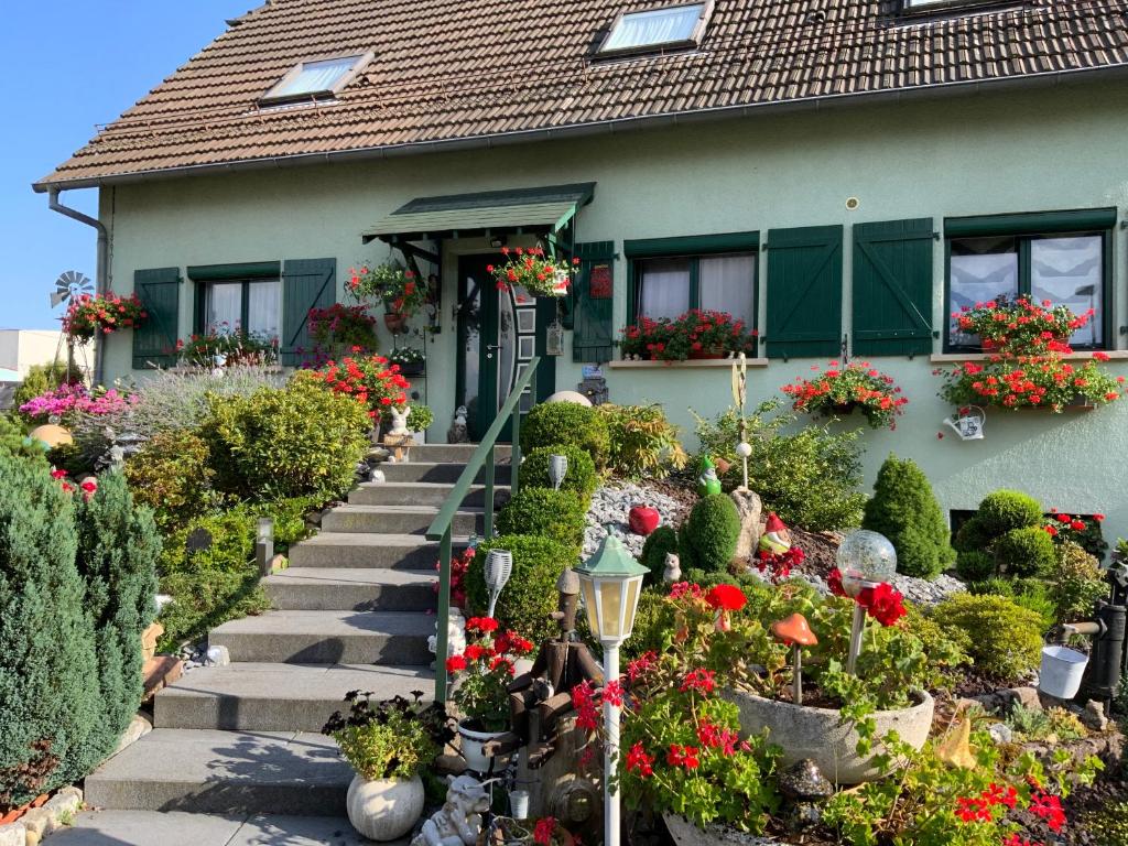 a house with flowers and plants in front of it at le nid fleuri de Cravanche in Cravanche