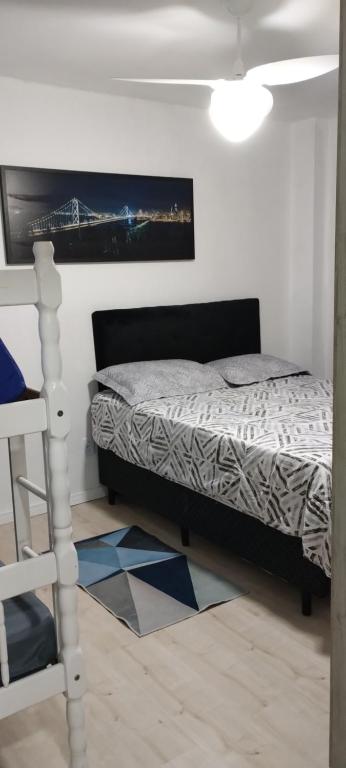 1 dormitorio con 1 cama y una pintura en la pared en 304 Capital da Amizade, en Itapema