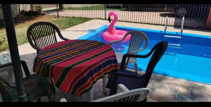 a table and chairs sitting next to a swimming pool at COYOTE POUSADA&HOSTEL in Foz do Iguaçu