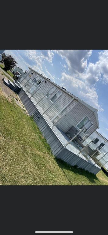 a building with a glass roof on top of a field at 2 bedroom (sleeps 6) caravan to rent in allonby in Maryport
