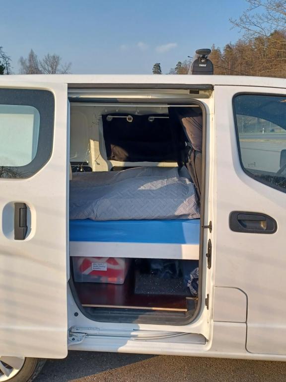 einem weißen Van mit offener Tür und einem Bett in der Unterkunft Marty's Campervan in Adliswil