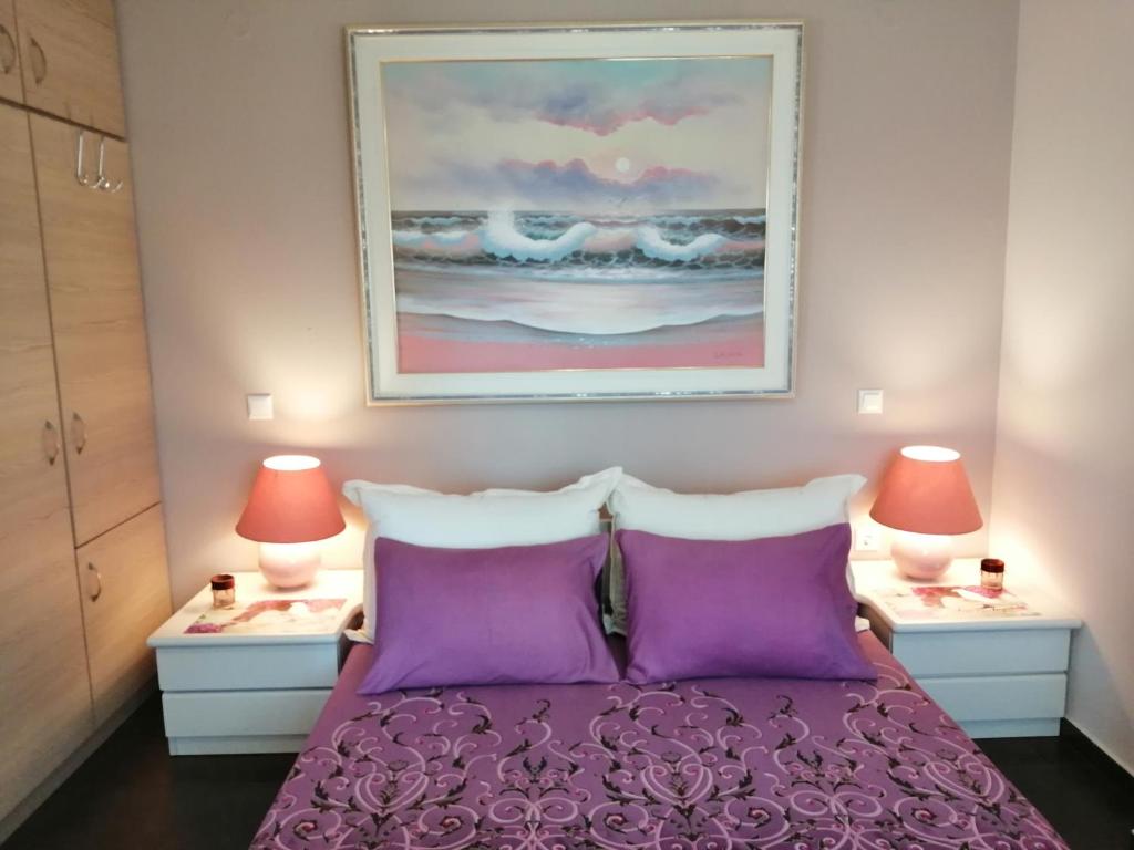 ein Schlafzimmer mit einem lila Bett und zwei Lampen in der Unterkunft Design Art Home in Zoödóchos