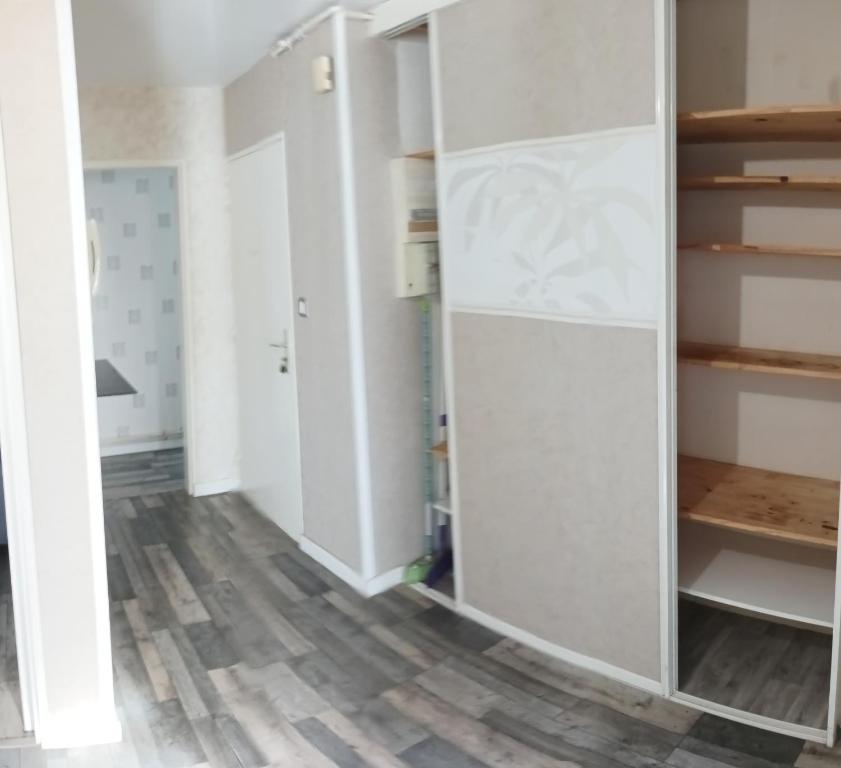 a room with white cabinets and a wooden floor at LENS, Bel appartement lumineux spacieux en centre ville 3 chambres in Lens