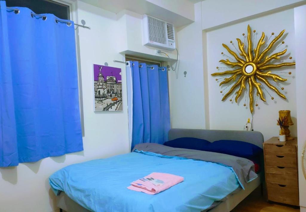 1 dormitorio con 1 cama con cortinas azules y espejo en Hantowah's Crib - Southwoods, en San Pedro