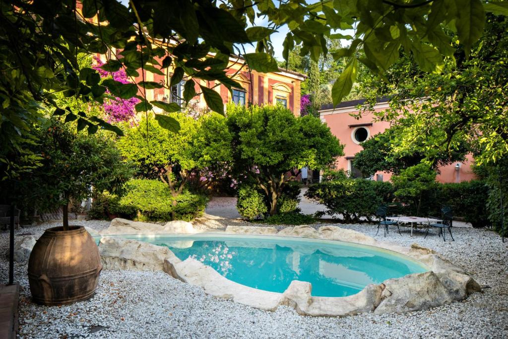 une piscine dans un jardin avec un grand arbre dans l'établissement B&B Relais Castelciala, à Nola