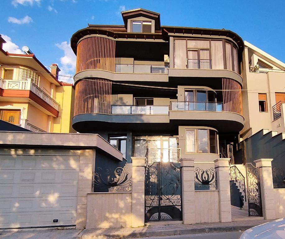 um edifício alto com uma cerca em frente em Vila Kace em Korçë