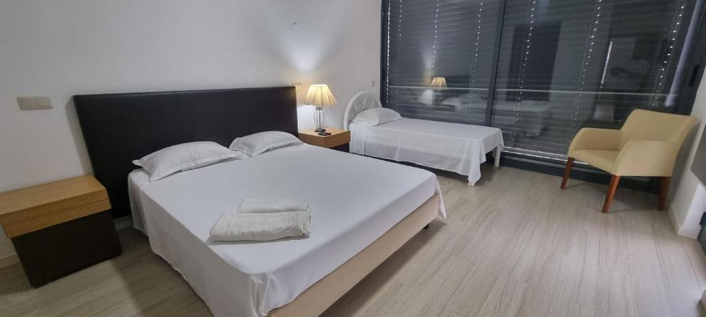 una camera con un grande letto bianco e una sedia di Kriol Guest House a Praia
