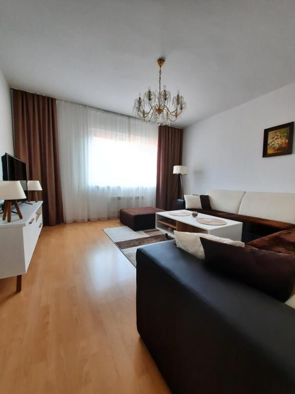 een woonkamer met een bank en een kroonluchter bij Apartment Emmi in Sarajevo