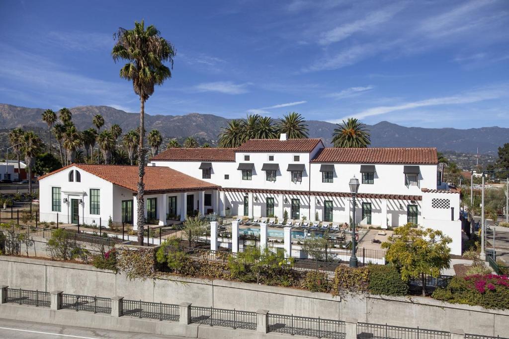 a white house with a palm tree in front of it at Moxy Santa Barbara in Santa Barbara