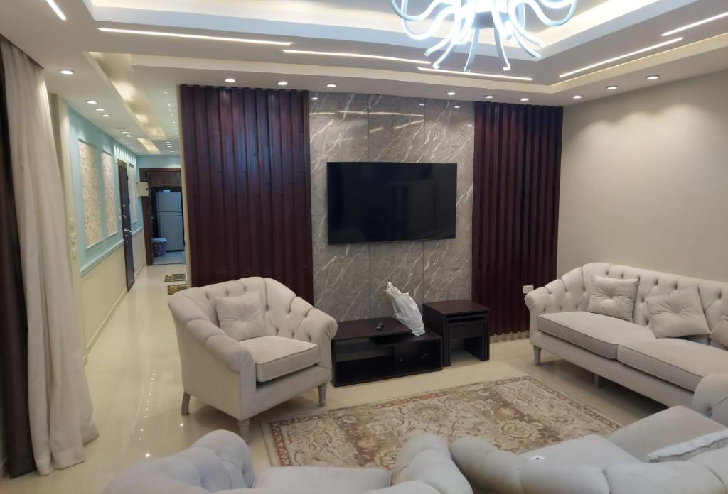 a living room with couches and a flat screen tv at زهرة الدقي in Cairo