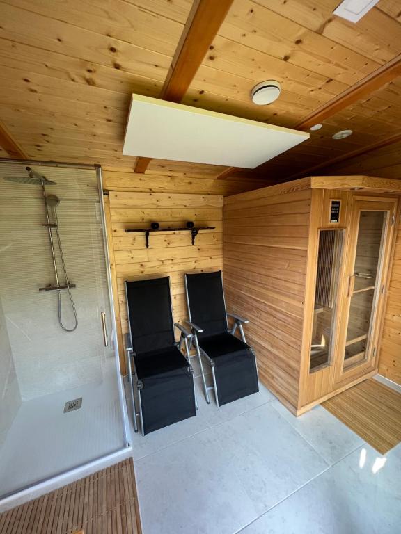 ein kleines Zimmer mit 2 Stühlen und einer Dusche in der Unterkunft Hiška Erika - Wood House Erika in Šoštanj