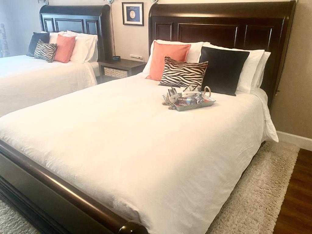 um quarto com 2 camas com lençóis brancos e almofadas em Rockwood House em Nanaimo
